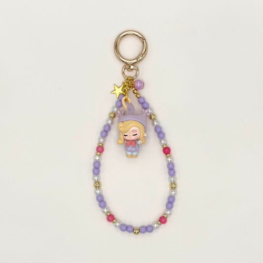 Keychain with a character charm and beaded chain on a light gray background