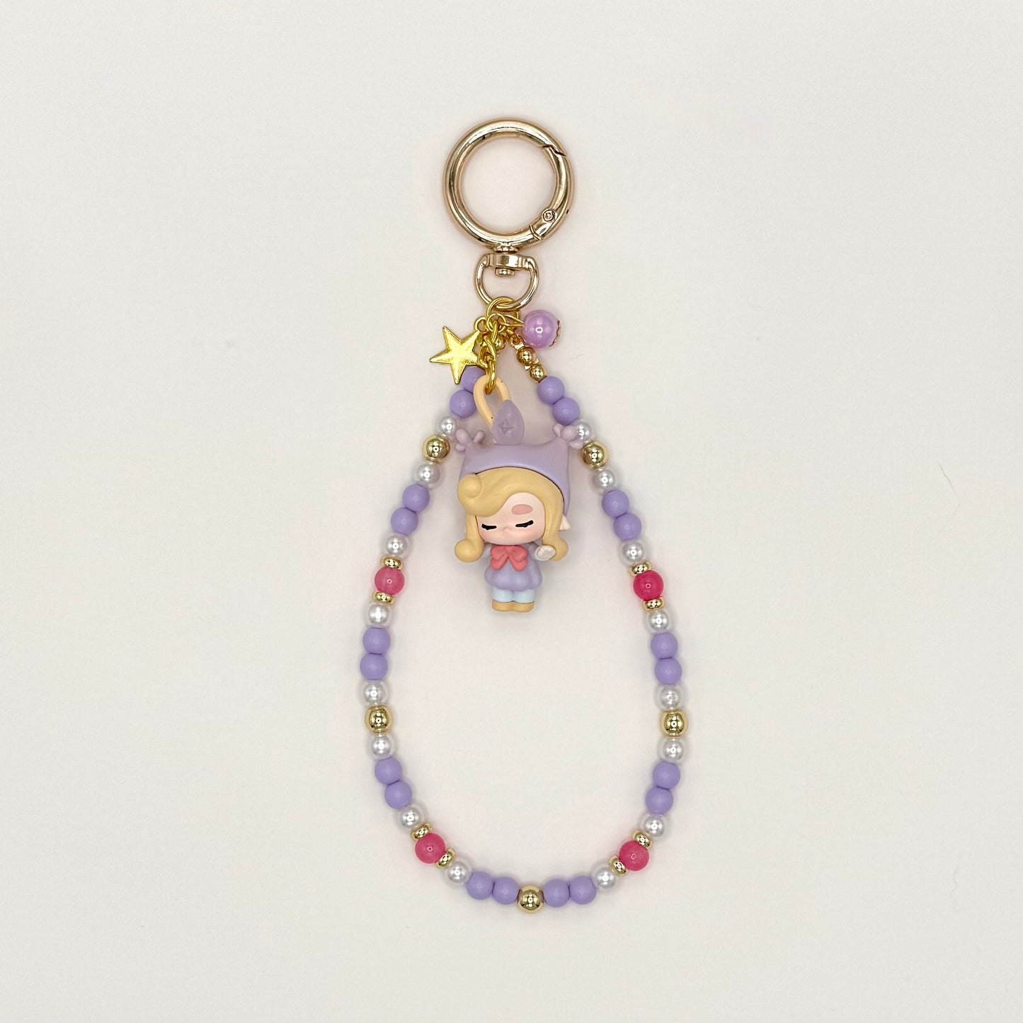 Keychain with a character charm and beaded chain on a light gray background