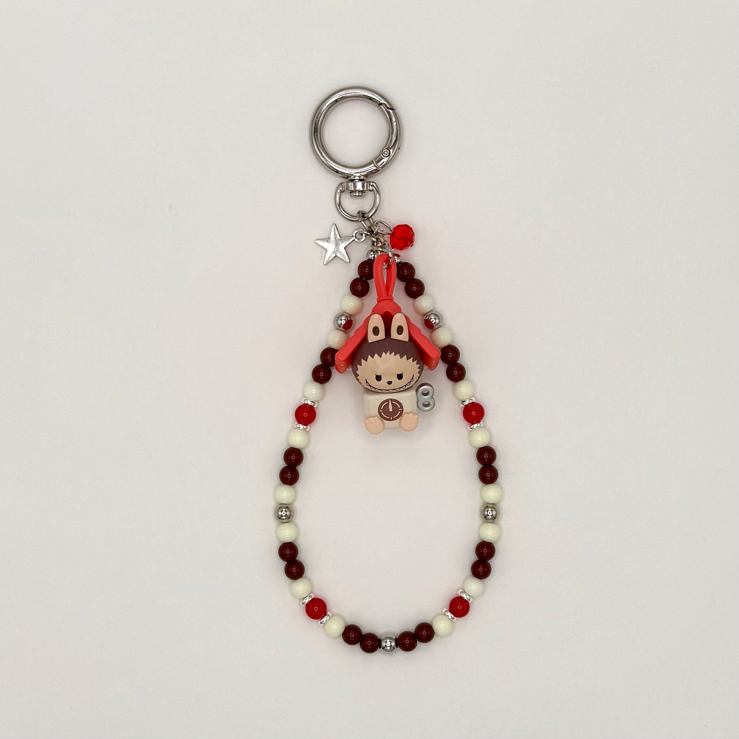 Keychain with beads and small character charm on a light gray background