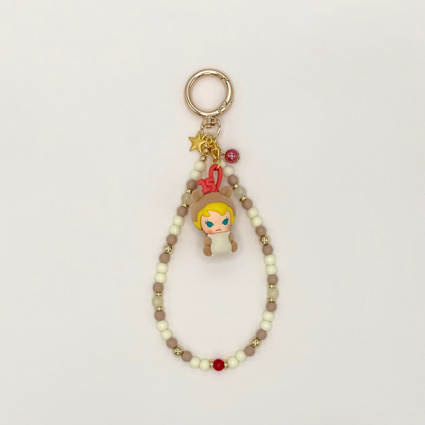 Keychain with character charm and beaded chain on a light gray background