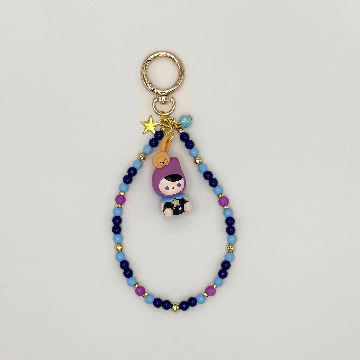 Beaded keychain with a character charm on a light gray background