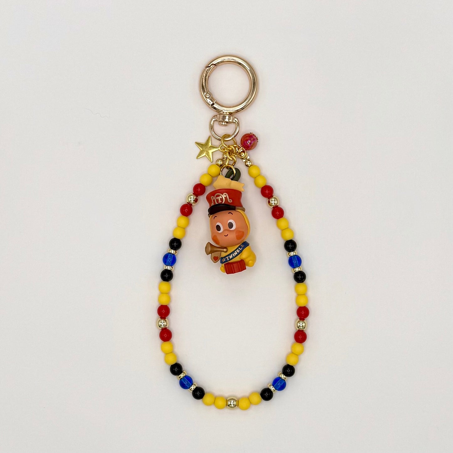Colorful beaded keychain with a small figurine on a light gray background