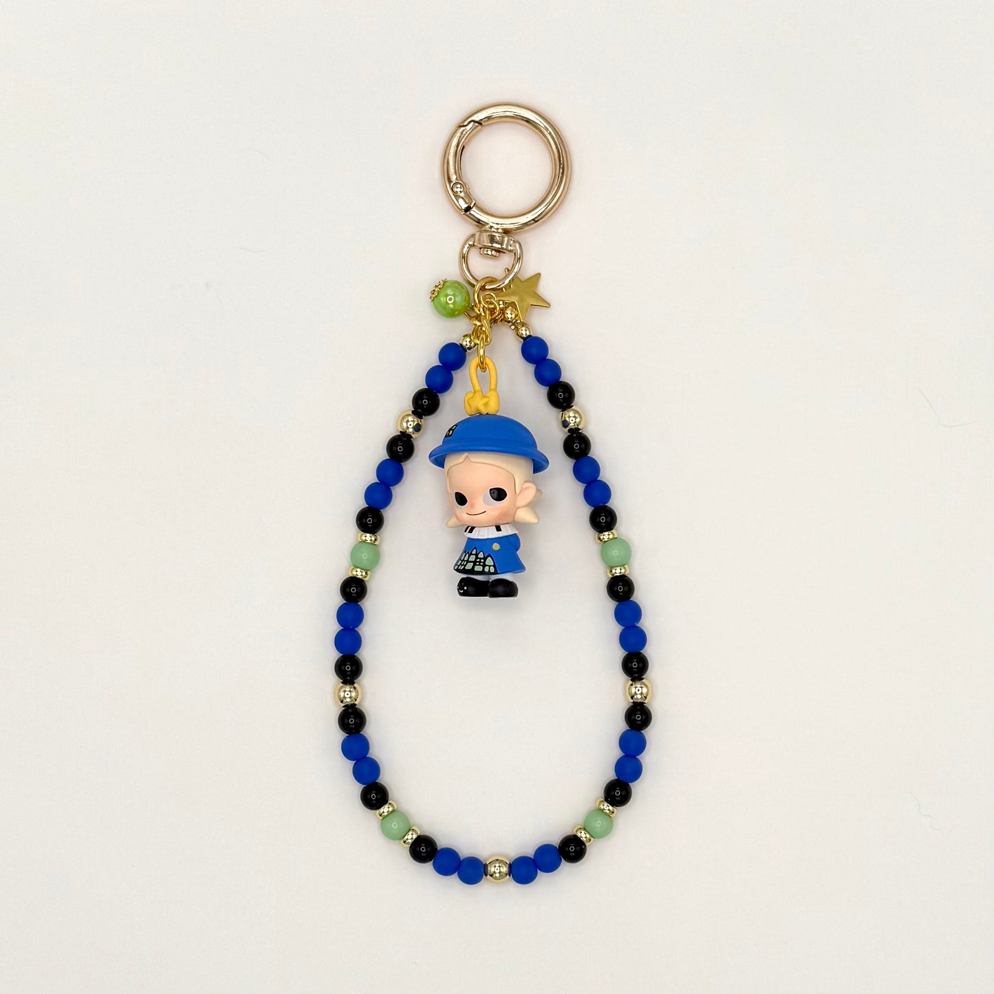 Beaded keychain with a small figurine on a light gray background