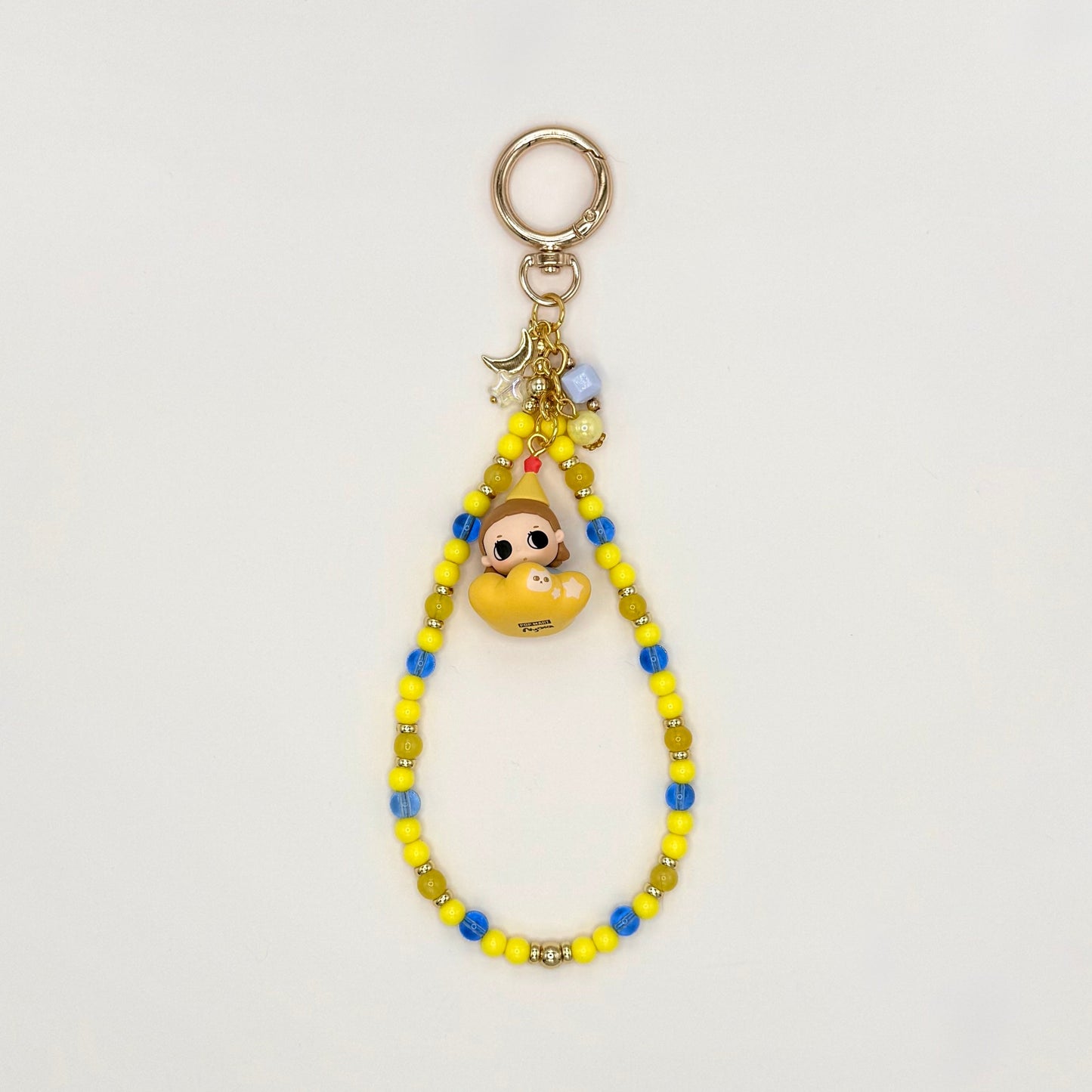 Colorful beaded keychain with a small character charm on a light gray background