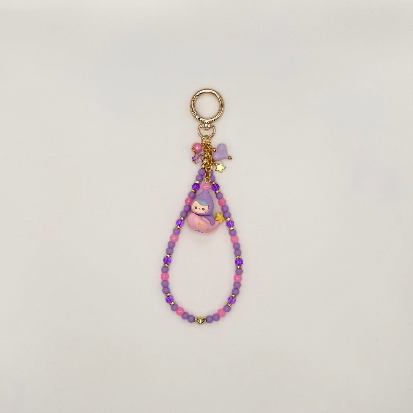 Beaded keychain with a small figurine on a light gray background