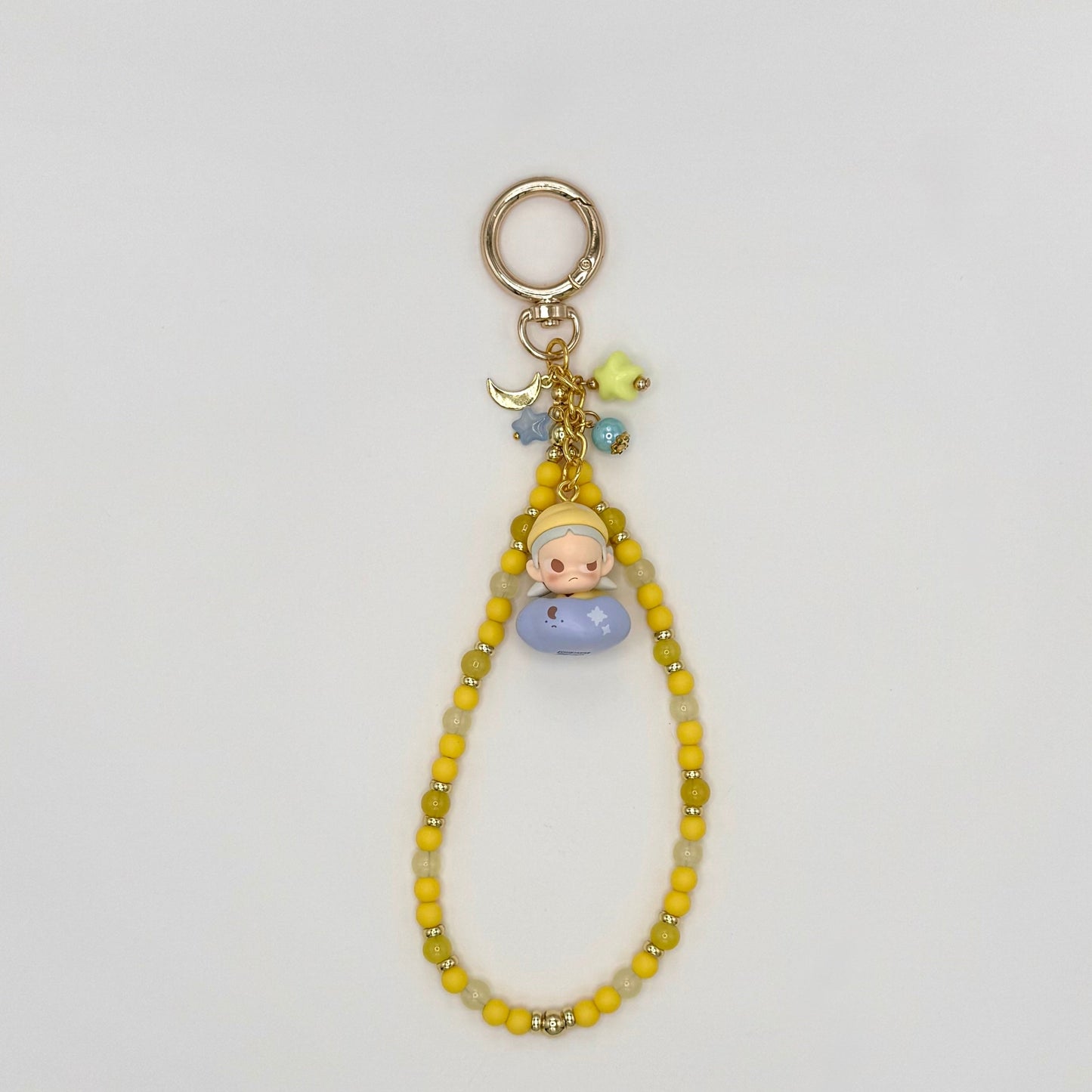 Keychain with a small figurine and beads on a light gray background